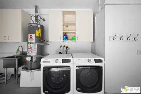 a utility room with dryer washer and a view of living room