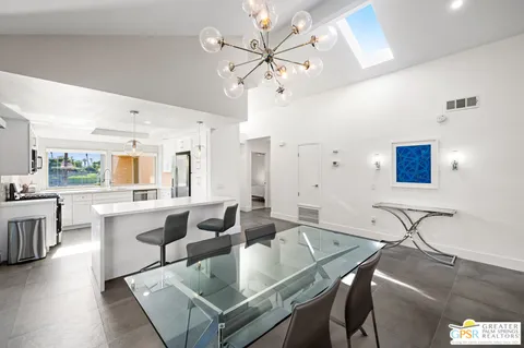 a large kitchen with a table chairs and a refrigerator