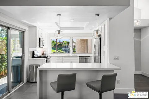 a kitchen with a table chairs refrigerator and window