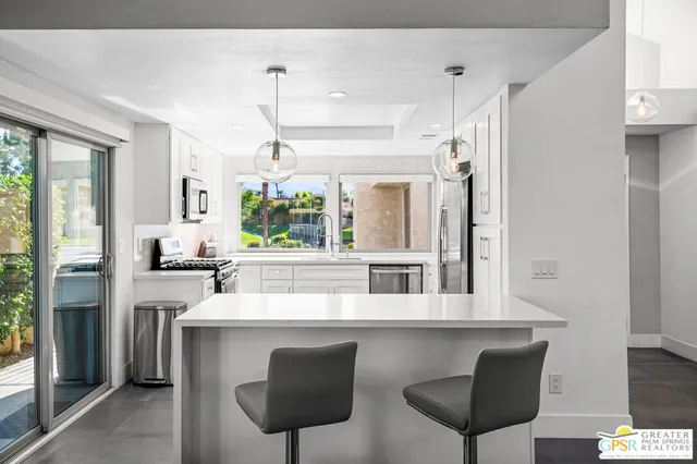 a kitchen with a table chairs refrigerator and window