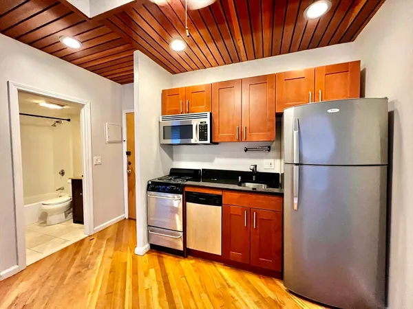 a kitchen with stainless steel appliances granite countertop a refrigerator a stove and a sink