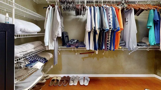 a view of walk in closet with clothes and shoes
