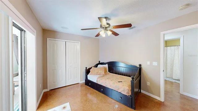 a bedroom with a bed and a chandelier fan