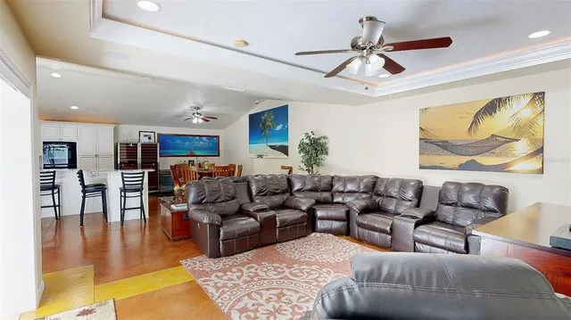a living room with furniture a rug and a ceiling fan