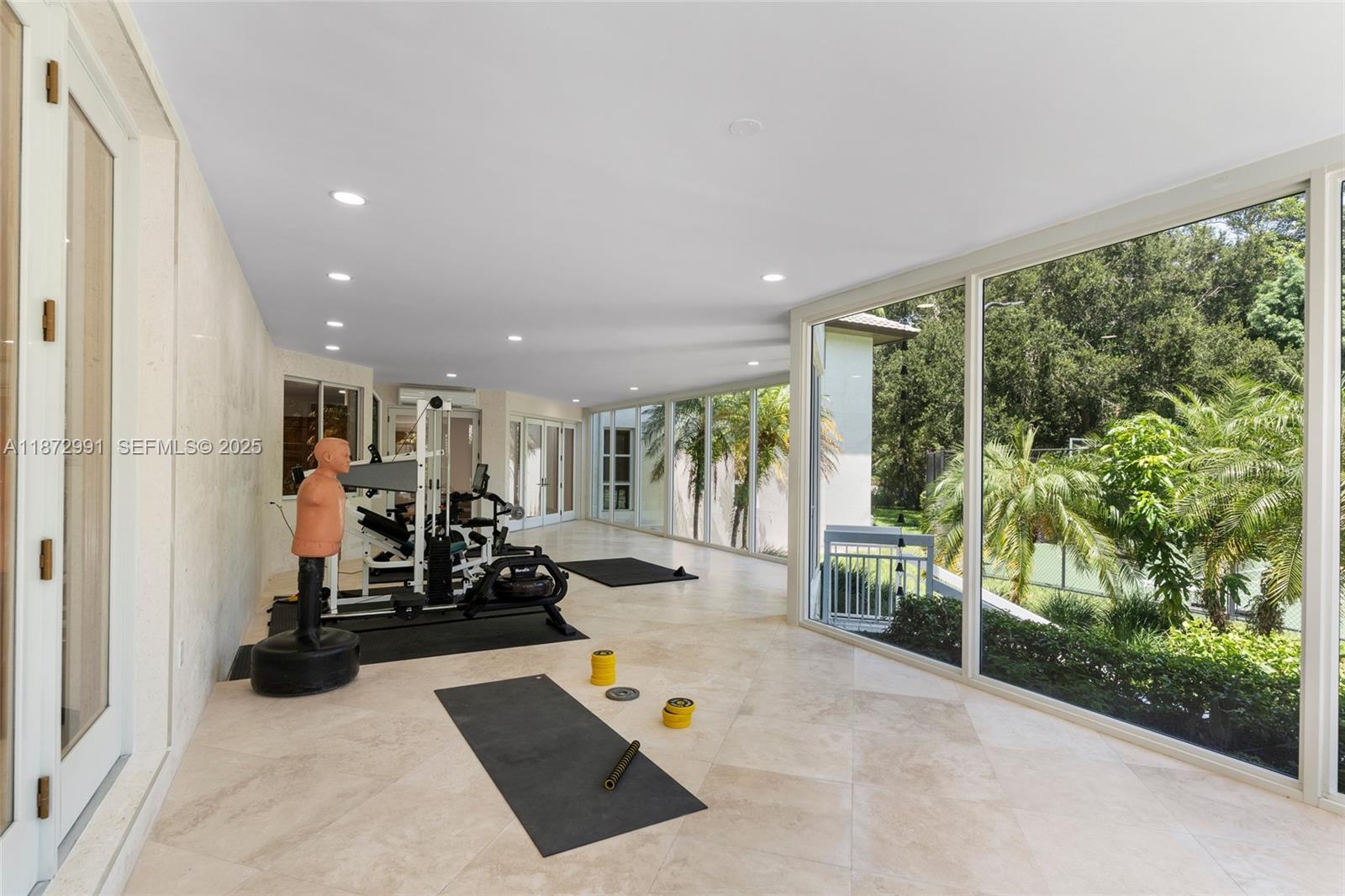 6190 Southwest 102nd Street Pinecrest, FL 33156 - Photo 22 of 52 a view of a room with gym equipment and floor to ceiling window