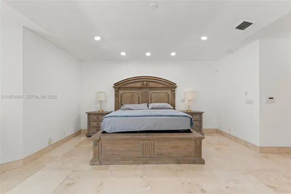 a spacious bedroom with a bed and a flat screen tv