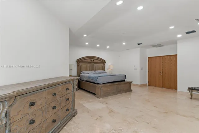 a spacious bedroom with a bed and a flat screen tv