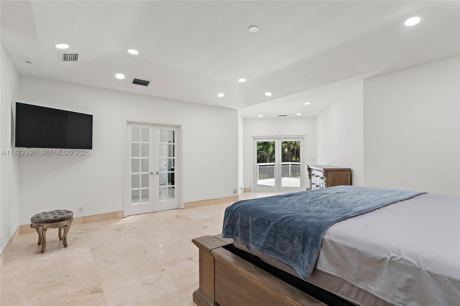6190 Southwest 102nd Street Pinecrest, FL 33156 - Photo 28 of 52 a spacious bedroom with a bed and a flat screen tv