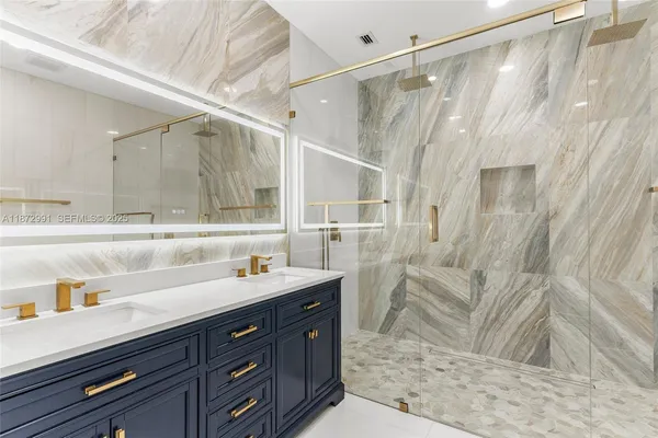 a bathroom with a sink mirror and shower