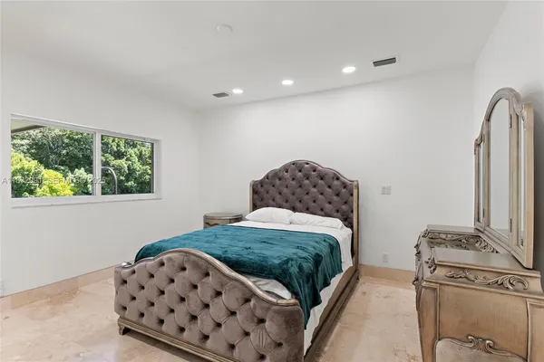 a bedroom with a large bed and a window