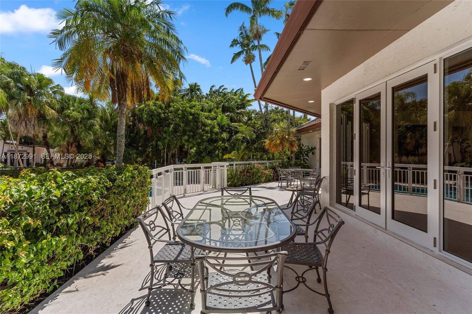 6190 Southwest 102nd Street Pinecrest, FL 33156 - Photo 38 of 52 a patio with a yard table and chairs