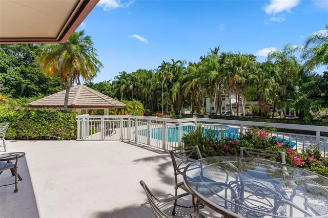 a view of a swimming pool with lawn chairs under an umbrella