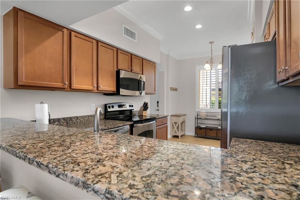 9719 Acqua Court, Unit 214 Naples, FL 34113 - Photo 12 of 50 a kitchen with stainless steel appliances granite countertop a sink stove and refrigerator