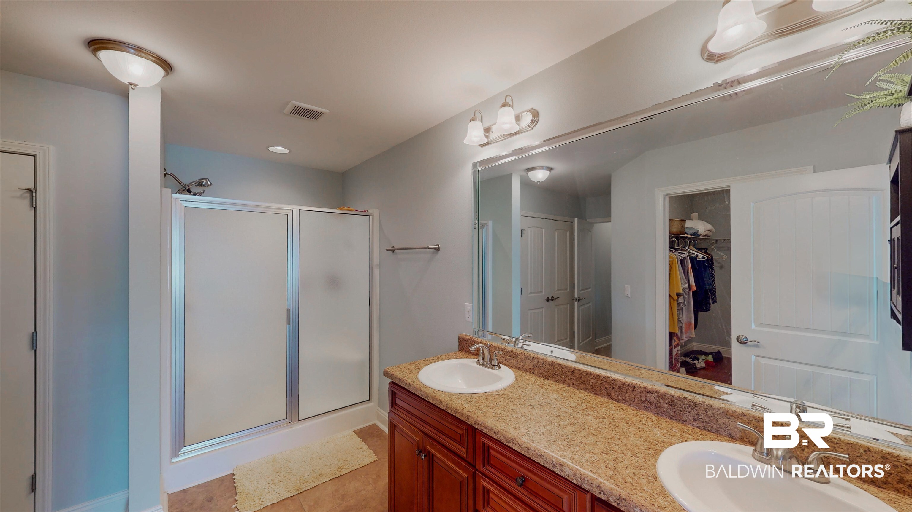 1704 Arcadia Drive Foley, AL 36535 - Photo 31 of 52 Bathroom featuring a shower stall, double vanity, a spacious closet, and tile patterned flooring