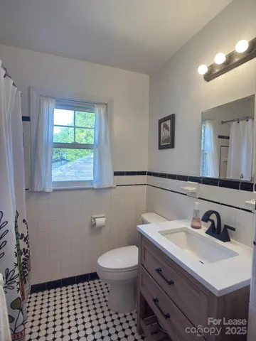 a bathroom with a sink a toilet and a mirror