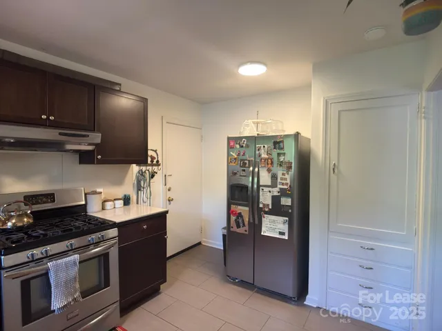 a kitchen with stainless steel appliances granite countertop a refrigerator and a stove