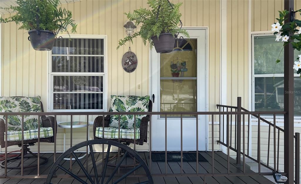 a view of a balcony with a potted plant and floor to ceiling window