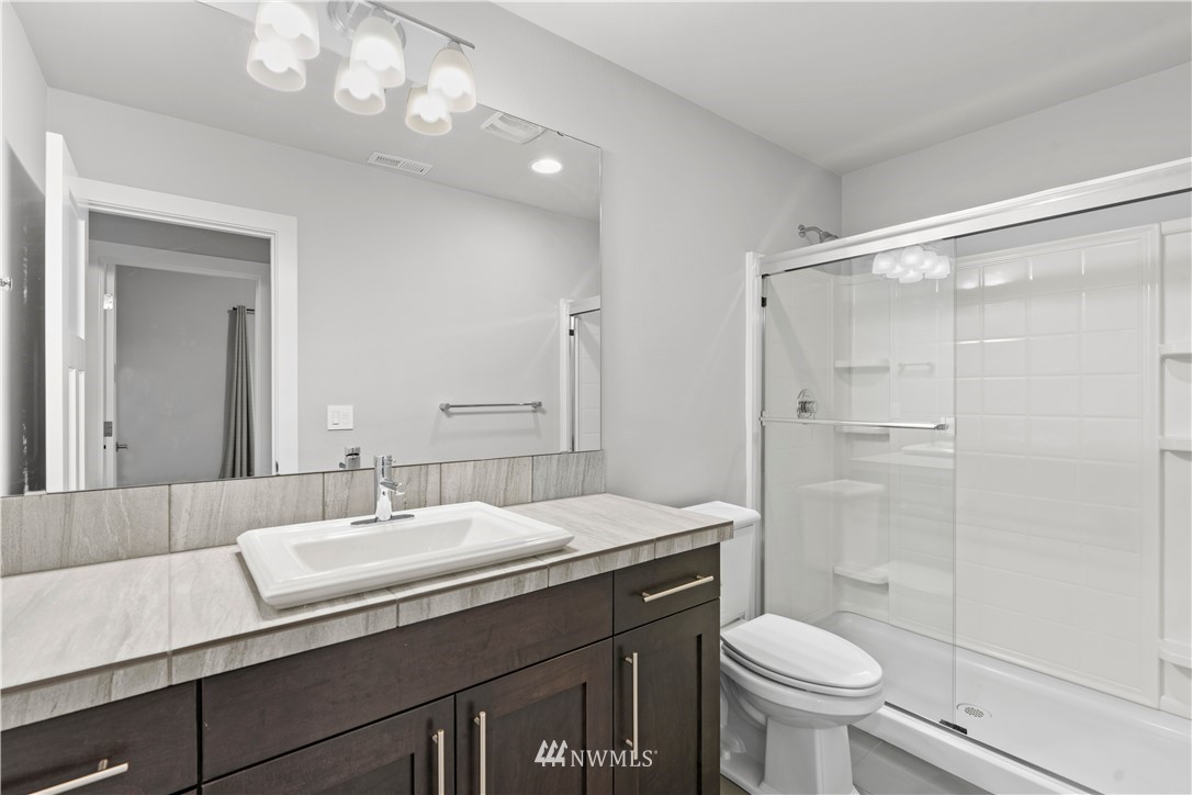 22708 41st Drive Southeast Bothell, WA 98021 - Photo 28 of 37 a bathroom with a sink a toilet a mirror and shower