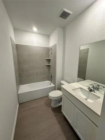 a view of kitchen with kitchen island a sink wooden floor and stainless steel appliances