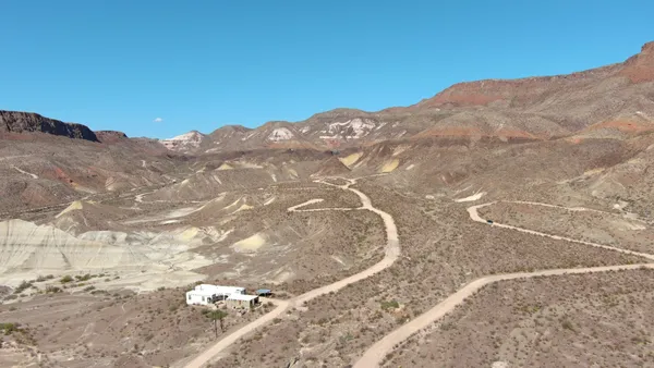 a view of a dry yard with mountains in the background