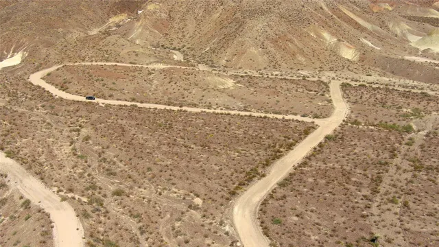 a view of a dry yard with mountains in the background