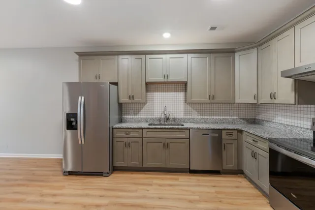 a kitchen with stainless steel appliances granite countertop a refrigerator and a sink