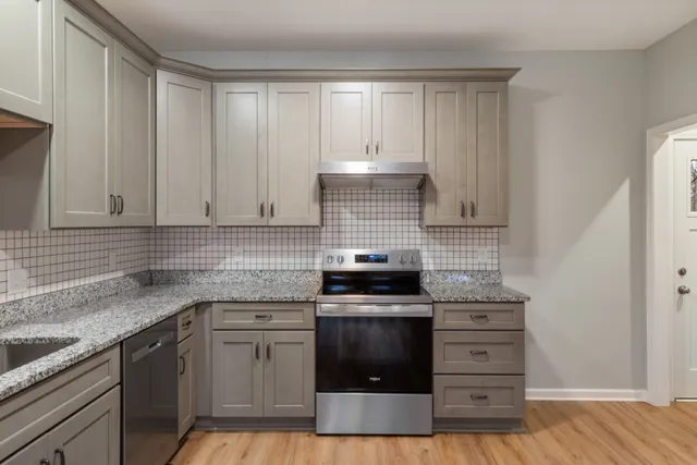 a kitchen with granite countertop a sink and cabinets