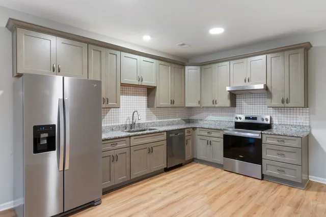 a kitchen with stainless steel appliances granite countertop a refrigerator sink and cabinets