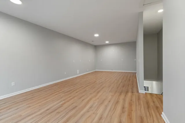 a view of empty room with wooden floor