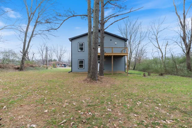 a view of a house with backyard and trees