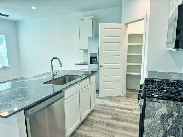 a kitchen with a sink stove and cabinets