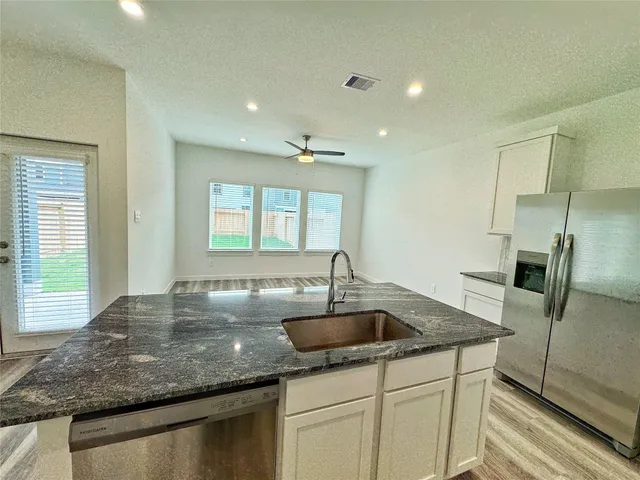 a kitchen with a sink a counter top space cabinets and stainless steel appliances