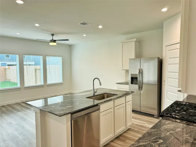 a kitchen with stainless steel appliances granite countertop a sink and a refrigerator