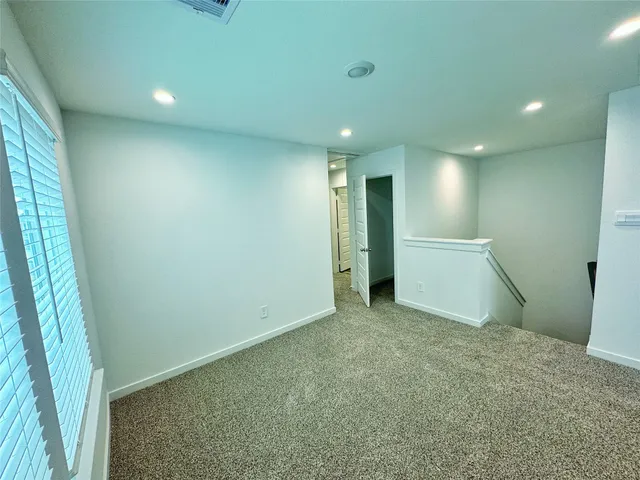 an empty room with closet and windows