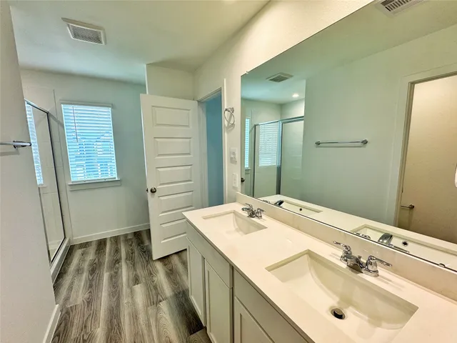 a bathroom with a shower sink and mirror