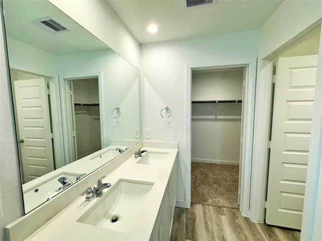 a bathroom with a sink a toilet a shower and a window