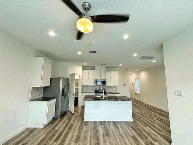a kitchen with stainless steel appliances a refrigerator sink and microwave