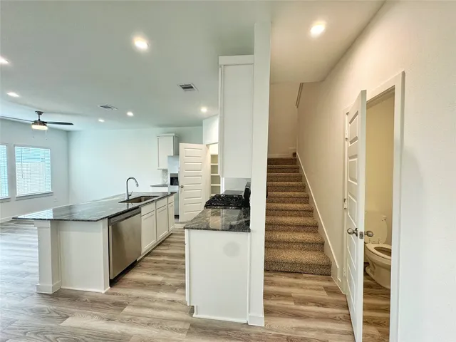a kitchen with white cabinets and sink