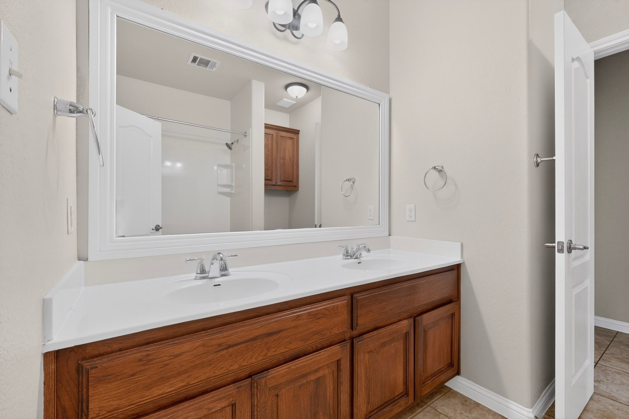 178 Limestone Trail Austin, TX 78737 - Photo 27 of 40 Double vanity with wood-finish cabinetry and white countertops
