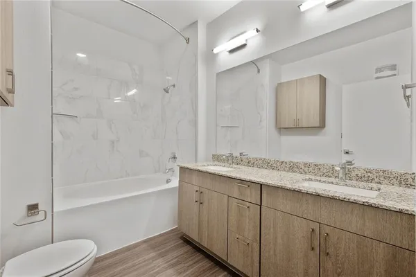 a bathroom with a granite countertop sink toilet and shower