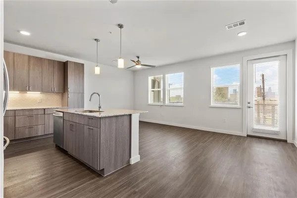 a kitchen with stainless steel appliances wooden floors and white cabinets