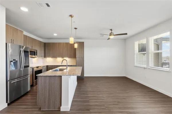 a kitchen with stainless steel appliances granite countertop a sink a stove and a refrigerator
