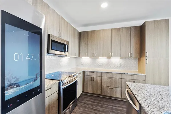 a kitchen with granite countertop wooden cabinets and stainless steel appliances