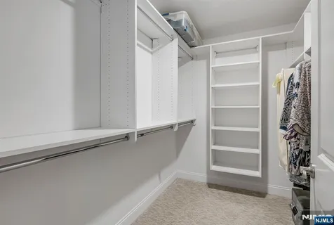 a view of walk in closet with empty racks
