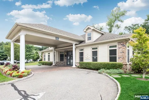 a front view of a house with a garden and plants
