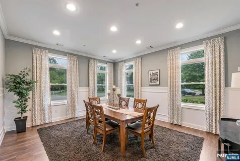 a dining room with furniture window and wooden floor