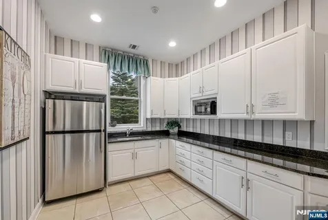 a kitchen with granite countertop white cabinets and white appliances