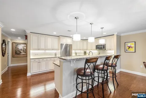 a kitchen with kitchen island wooden cabinets and refrigerator