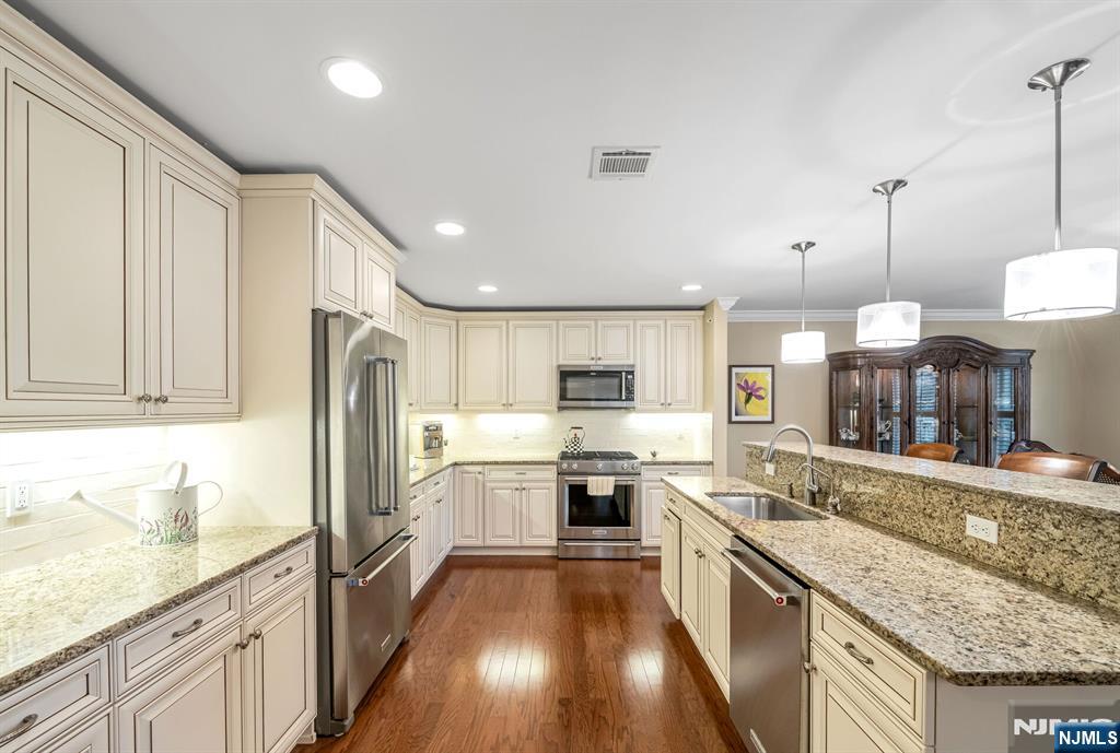 1508 Whitney Lane, Unit 1508 Allendale, NJ 07401 - Photo 6 of 24 a large kitchen with stainless steel appliances granite countertop a refrigerator a sink dishwasher a stove and white cabinets with wooden floor
