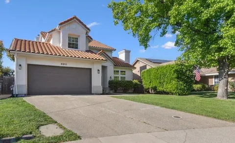 a front view of a house with yard and green space